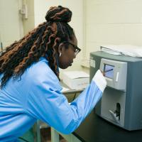 A researcher uses the cell counter equipment.